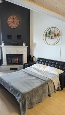 a bedroom with a large bed and a fireplace at O'Berge du Village C304 - Bord de l'eau in Magog-Orford