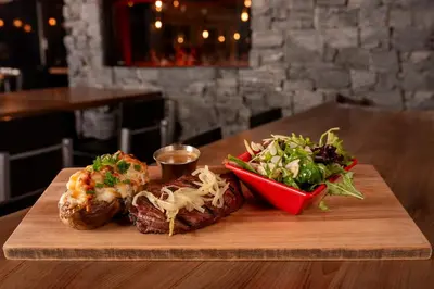 a wooden cutting board with a sandwich and a salad at Hotel-Resto-Bar Le Journel in Saint-Joseph-de-Beauce