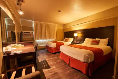 a hotel room with two beds and a desk at Hotel-Resto-Bar Le Journel in Saint-Joseph-de-Beauce