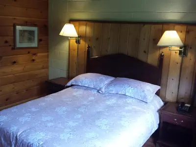 a bedroom with a large bed with two lights on it at Motel Le Charentais in Sorel