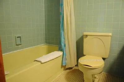a bathroom with a toilet and a tub and a sink at Motel Le Charentais in Sorel
