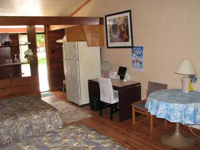 a bedroom with a desk and a bed and a table at Motel Le Charentais in Sorel