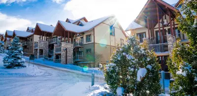 a lodge in the winter with snow on the ground at Condos Château-Bromont in Bromont