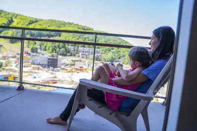 a woman and a little girl sitting on a balcony at Condos Château-Bromont in Bromont