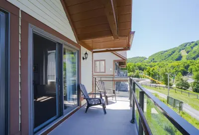 a porch with a chair and a balcony with a view at Condos Château-Bromont in Bromont