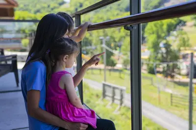 a man and two little girls looking out of a window at Condos Château-Bromont in Bromont