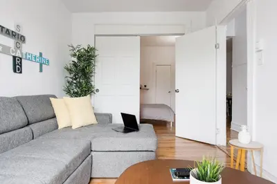 a living room with a couch and a laptop on a table at Apartments Near Montreal Olympic Park in Montréal