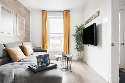 a living room with a couch and a tv at Apartments Near Montreal Olympic Park in Montréal