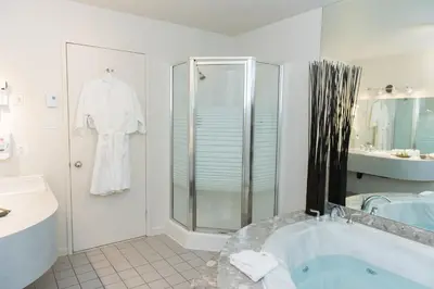 a bathroom with a shower and a bath tub at Hôtel Le Floral in Sherbrooke