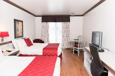 a hotel room with two beds and a television at Hôtel Le Floral in Sherbrooke
