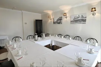 a group of tables with white table cloths in a room at Hôtel Le Floral in Sherbrooke