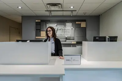 a woman standing behind a counter in an office at Holiday Inn Express Hotel & Suites Saint - Hyacinthe by IHG in Saint-Hyacinthe
