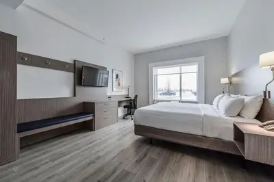 a bedroom with a large bed and a flat screen tv at Holiday Inn Express Hotel & Suites Saint - Hyacinthe by IHG in Saint-Hyacinthe