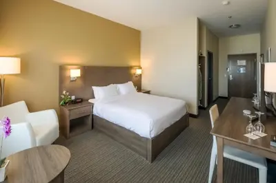 a hotel room with a bed and a desk at Imperia Hôtel et Suites Terrebonne in Terrebonne