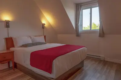 a bedroom with a large bed and a window at Hotel Cowansville in Cowansville