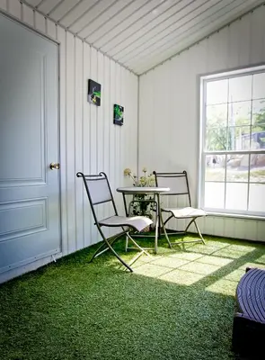 two chairs and a table in a room with grass at Auberge Papillon Lune in Richmond