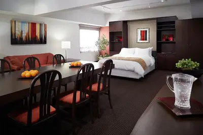 a bedroom with a bed and a table and chairs at Hotel Ruby Foo's in Montréal