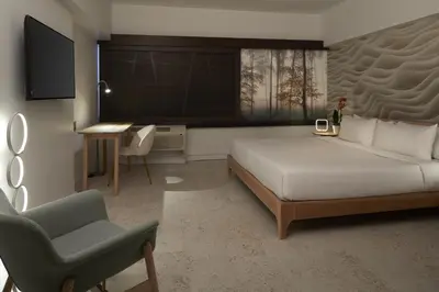 a bedroom with a bed and a chair and a desk at Hotel Ruby Foo's in Montréal