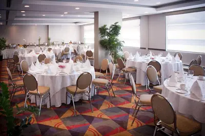 a banquet hall with white tables and chairs at Hotel Ruby Foo's in Montréal