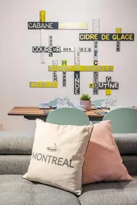 a couch with a pillow in front of a table at Alywin Apartments in Hochelaga in Montréal
