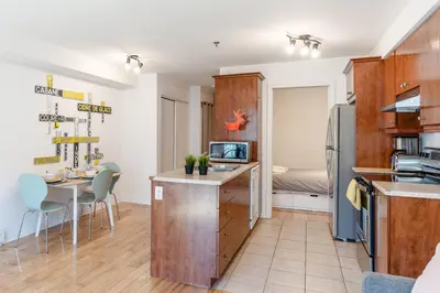 a kitchen with a counter and a table with chairs at Alywin Apartments in Hochelaga in Montréal