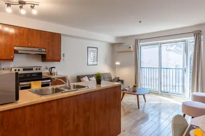 a kitchen and living room with a large window at Alywin Apartments in Hochelaga in Montréal