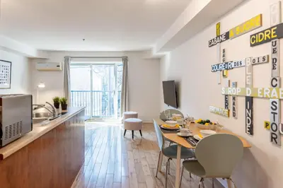 a living room with a table and chairs and a kitchen at Alywin Apartments in Hochelaga in Montréal