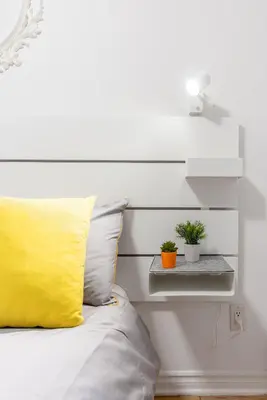 a bed with a yellow pillow and two potted plants at Alywin Apartments in Hochelaga in Montréal