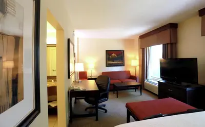 a hotel room with a desk and a room at Hampton Inn & Suites Laval in Laval