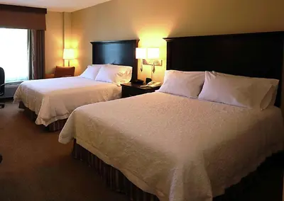 a hotel room with two beds and a window at Hampton Inn & Suites Laval in Laval