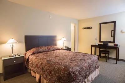 a hotel room with a bed and a desk at Motel Du Fleuve in Brossard