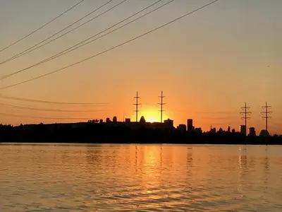 a sunset over the water with a city in the background at Motel Du Fleuve in Brossard