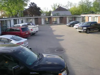 a group of cars parked in a parking lot at Motel Seigneurie de Vaudreuil in Vaudreuil-Dorion