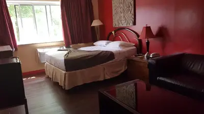 a hotel room with a bed and a couch at Chomedey Inn in Laval