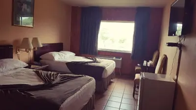 a hotel room with two beds and a window at Chomedey Inn in Laval