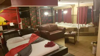 a bathroom with a couch and a sink and a chair at Chomedey Inn in Laval