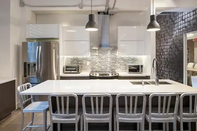 a kitchen with a large white island with chairs at The Holland Hotel by Simplissimmo in Montréal
