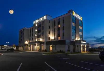 a hotel in a parking lot at night at Imperia Hôtel et Suites Boucherville in Boucherville