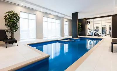 a large pool with blue water in a building at Imperia Hôtel et Suites Boucherville in Boucherville