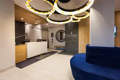 an office lobby with a blue couch and a chandelier at Imperia Hôtel et Suites Boucherville in Boucherville