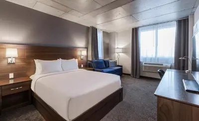 a hotel room with a large bed and a desk at Imperia Hôtel et Suites Boucherville in Boucherville