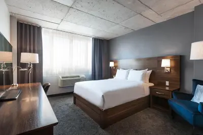a hotel room with a bed and a desk at Imperia Hôtel et Suites Boucherville in Boucherville