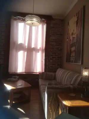 a living room with a couch and a window at Vieux-Old Farnham Appart-Condotel in Farnham