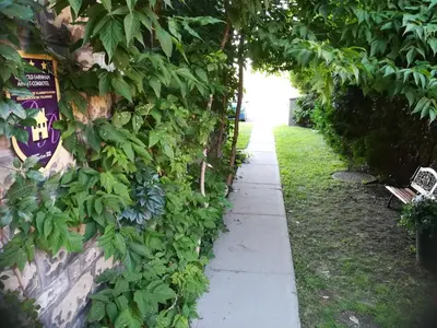 a garden path with a bench next to a wall at Vieux-Old Farnham Appart-Condotel in Farnham