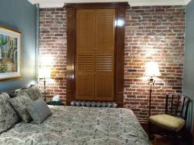 a bedroom with a bed and a brick wall at Vieux-Old Farnham Appart-Condotel in Farnham