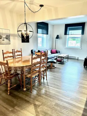 a dining room with a table and chairs and a couch at Sutton - Condo Au Coeur du Village in Sutton