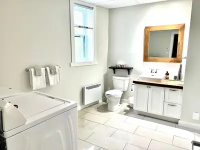 a white bathroom with a sink and a toilet at Sutton - Condo Au Coeur du Village in Sutton