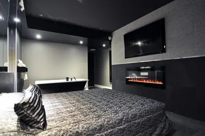 a bedroom with a bed and a tv and a fireplace at Complexe Hotelier Le 55 in Bécancour