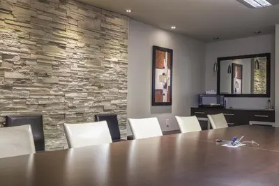 a conference room with a wooden table and white chairs at Complexe Hotelier Le 55 in Bécancour