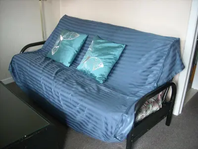 a bed with blue sheets and two blue pillows at Motel le Verseau in Sorel